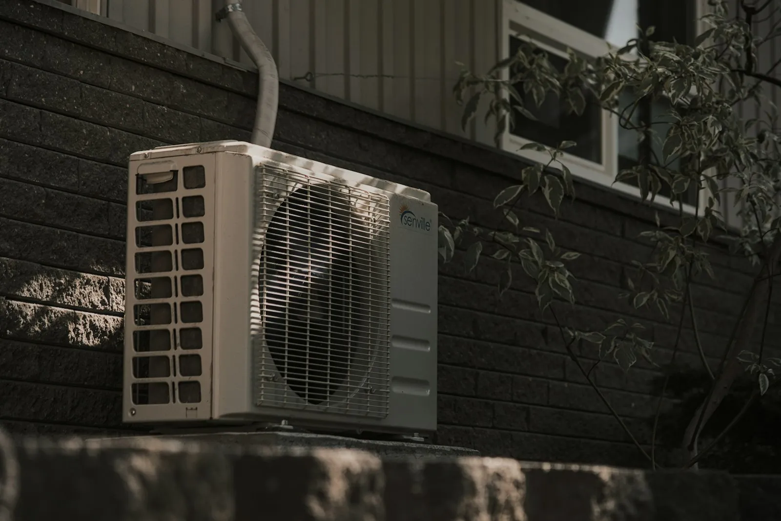 Teknisi sedang membersihkan filter AC unit indoor di rumah warga